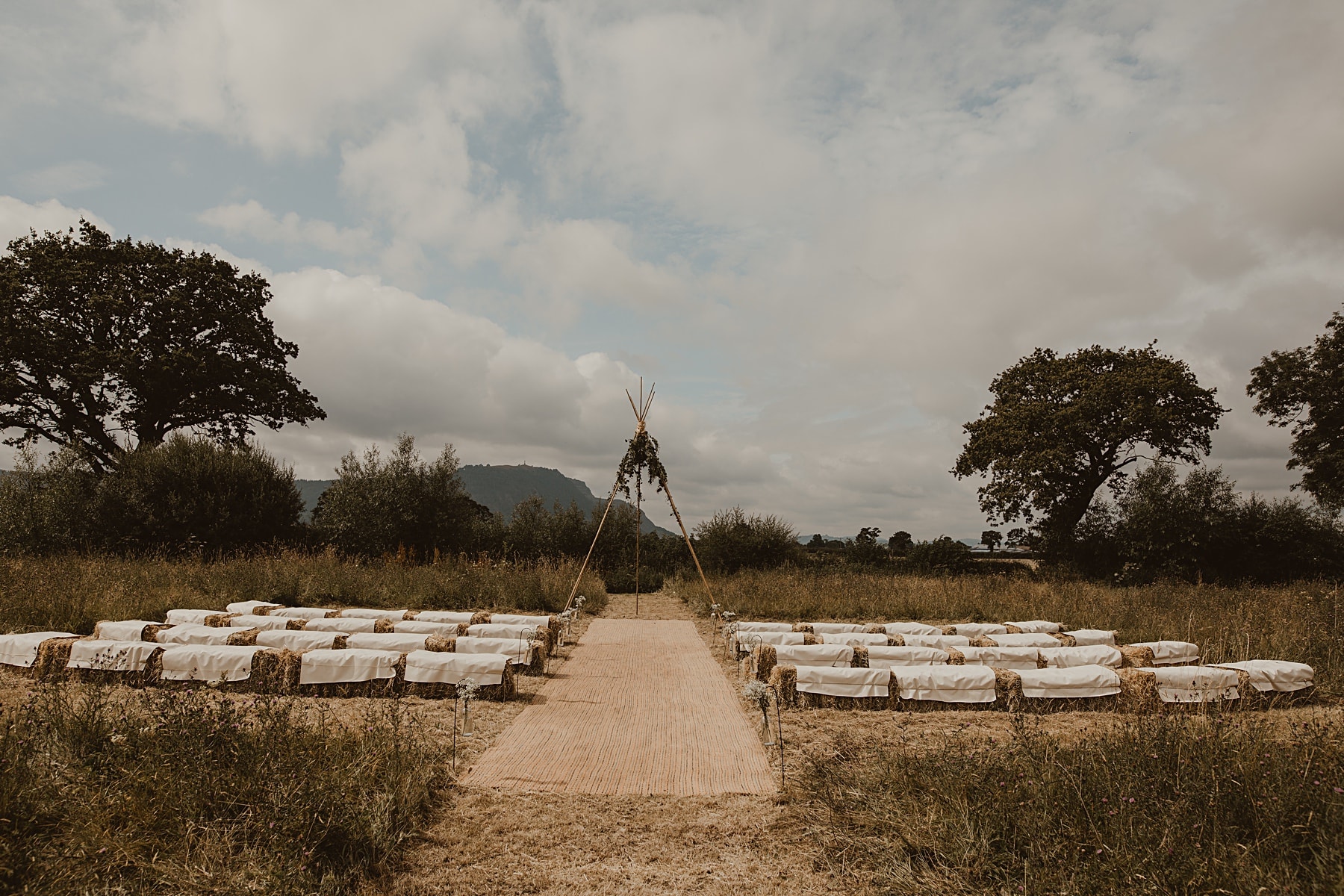 Ceremony tipi in field with hay bales
