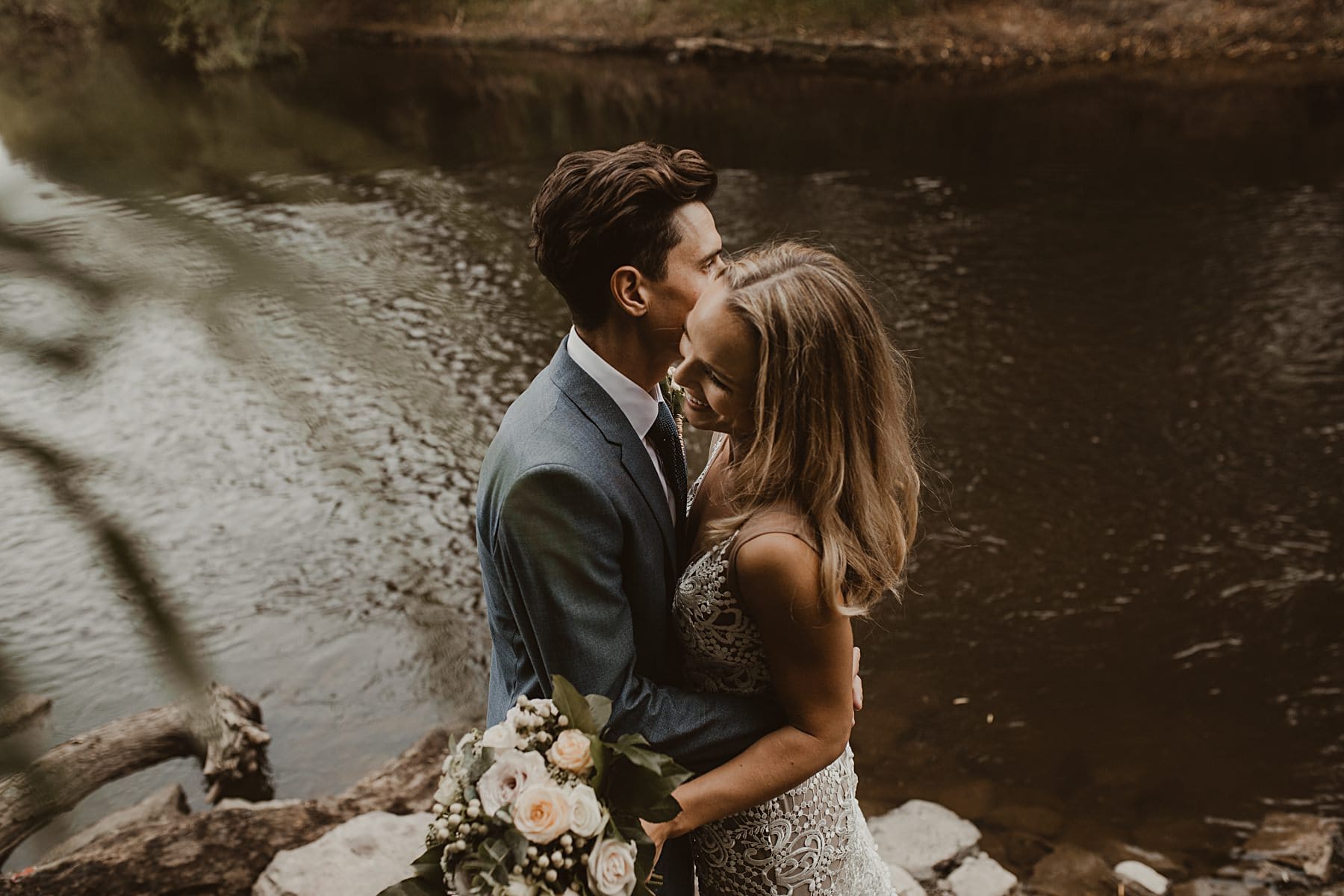 cuddling by a river - relaxed wedding photography