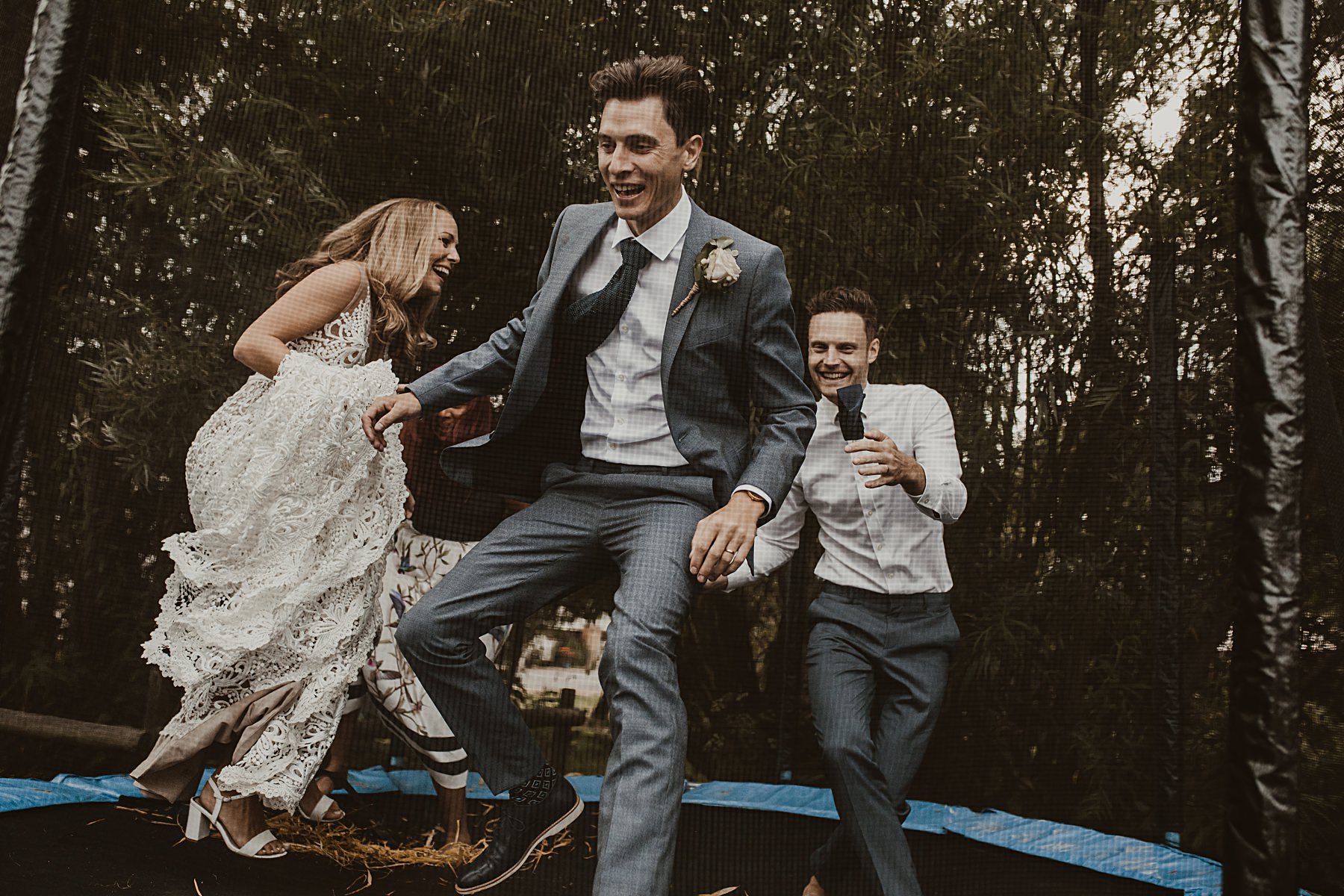 Bride and groom jumping on trampoline