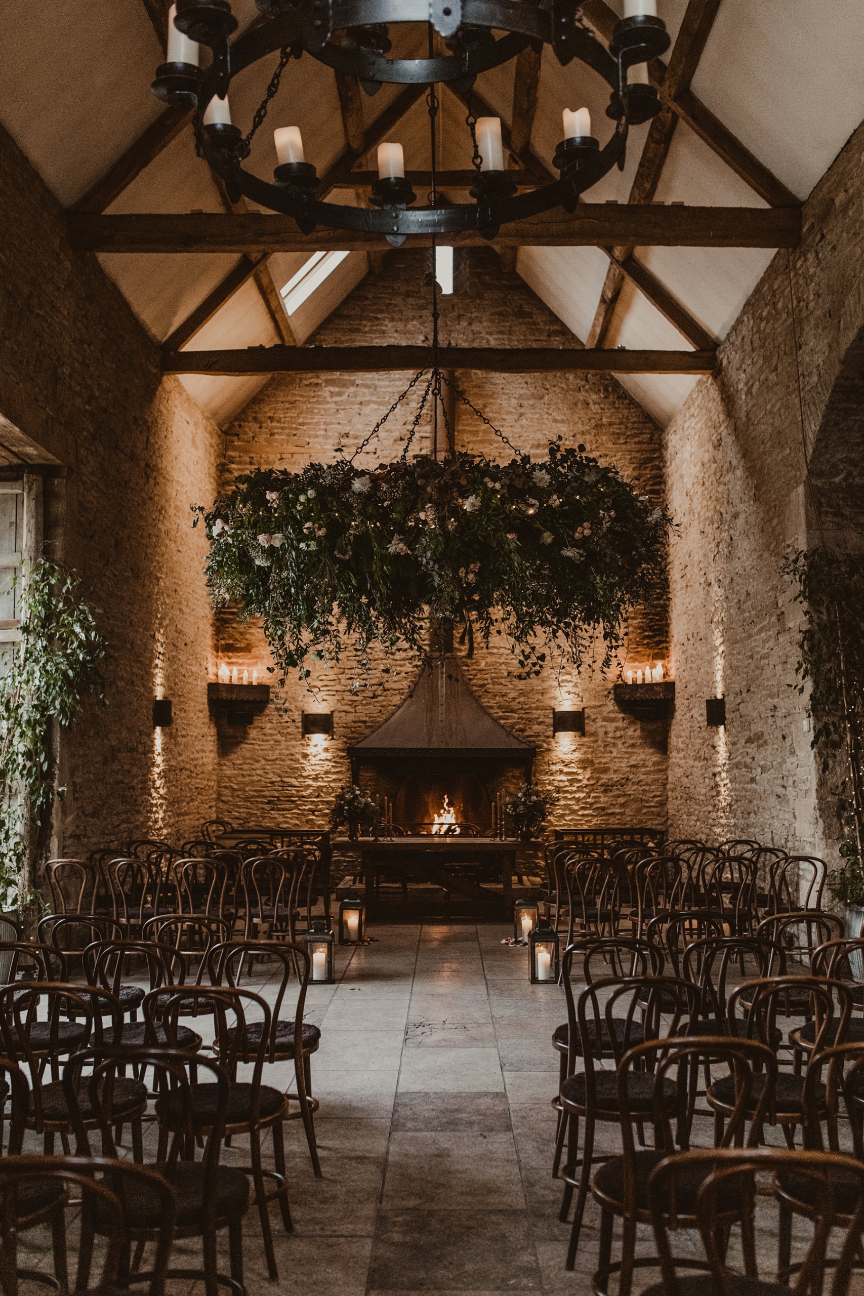 Foliage installation decorating ceremony room with fireplace at Stone Barn 