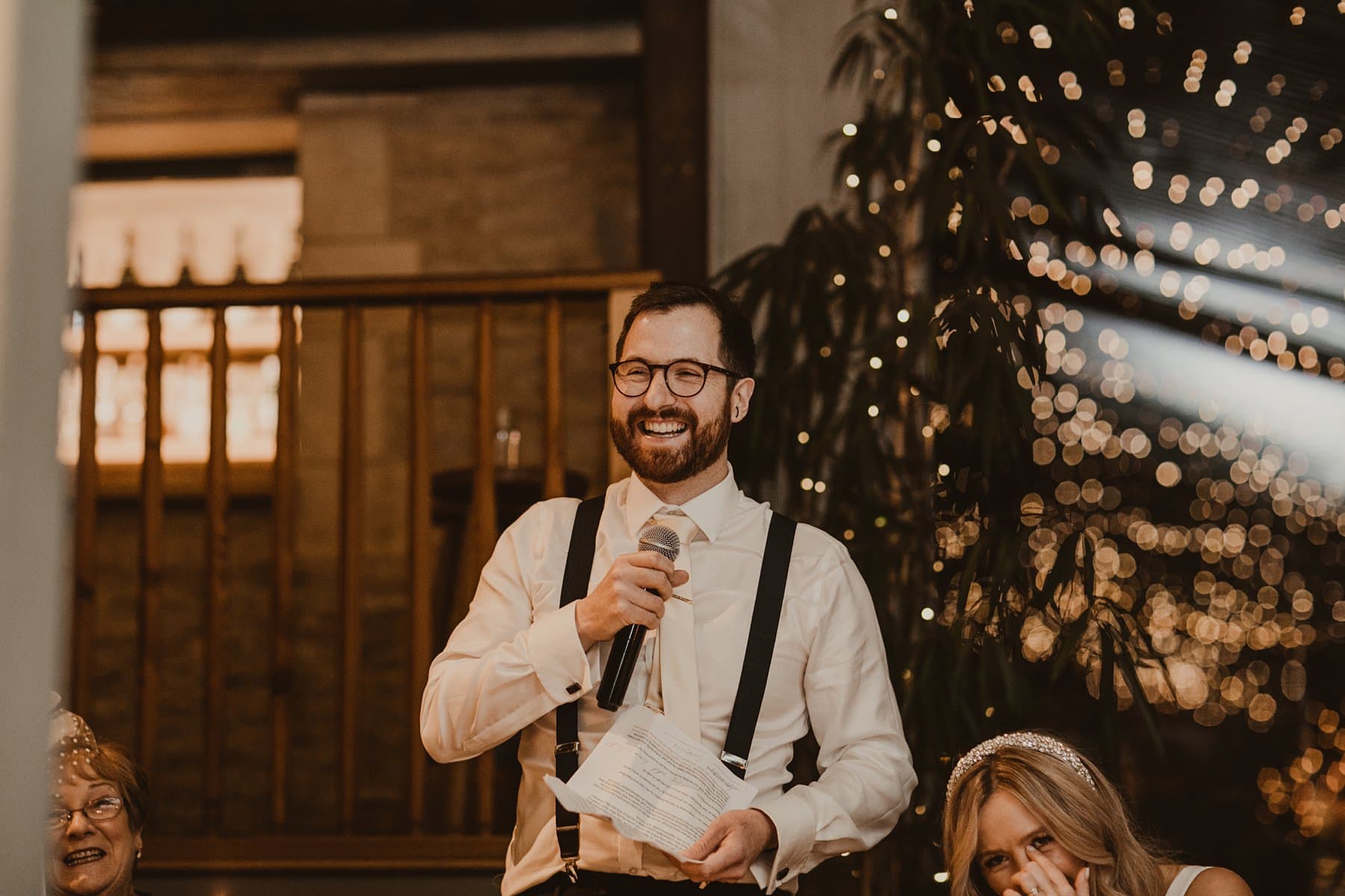 Groom laughing whilst doing his speech