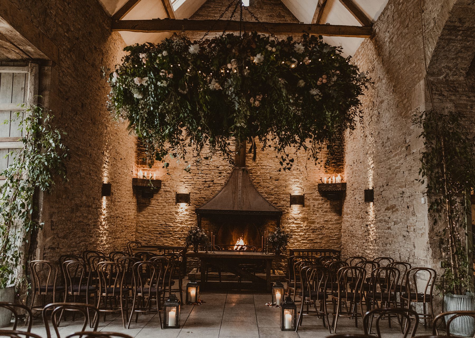 Foliage installation decorating ceremony room with fireplace at Stone Barn 